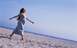 Pregnant Woman Strolling Along the Beach